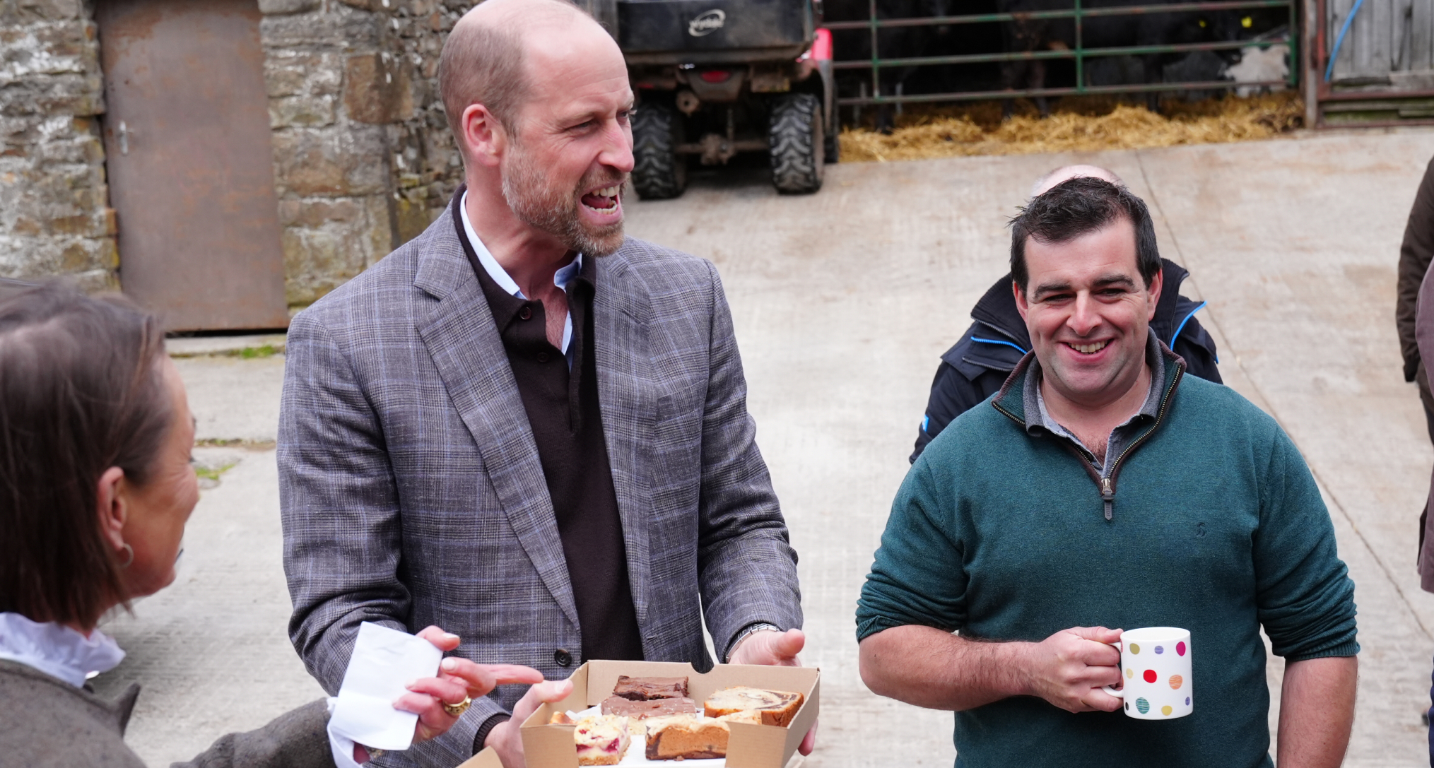 Prince William in a gray blazer smiling at farmers