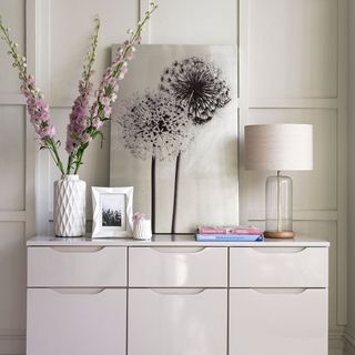 mink grey shade sideboard with white flower was and table lamp