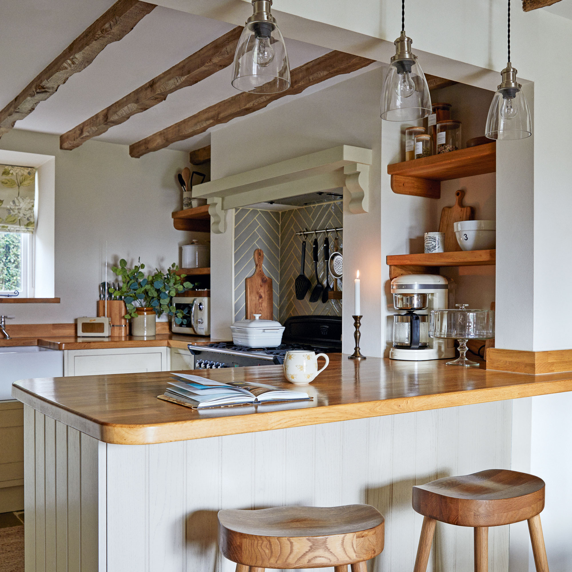 White cottage kitchen with wooden counter tops and a peninsula island with wooden breakfast bar stools.
