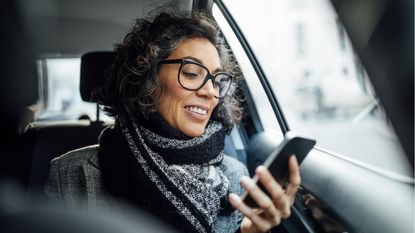 A wealthy woman checks her phone while riding in a limo.