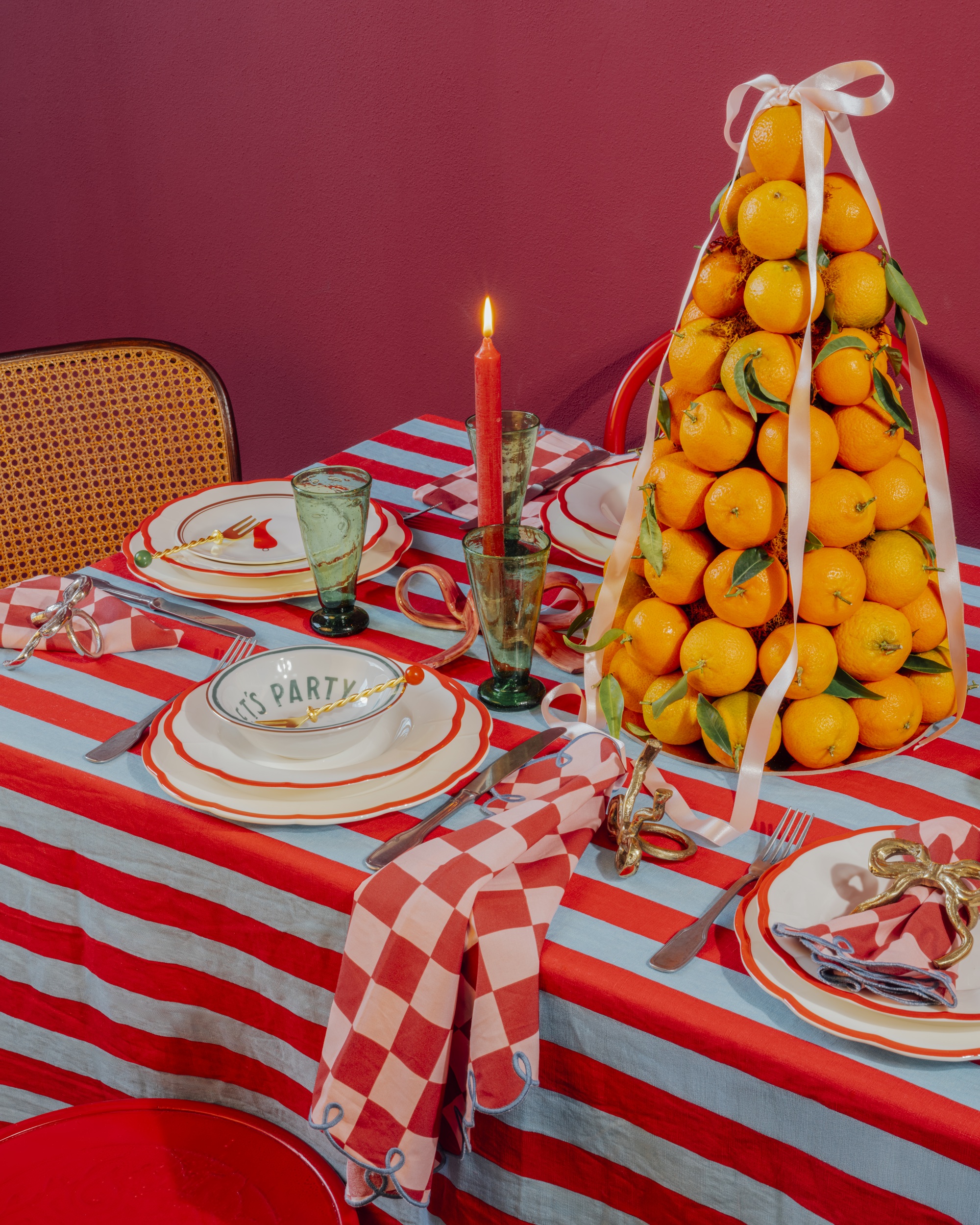 a colorful table set for a dinner party with an orange cone centerpiece