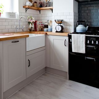 white themed kitchen with wooden countertop and laminated cabinets
