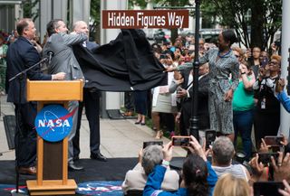 The new street sign for Hidden Figures Way outside NASA headquarters in Washington is unveiled during a ceremony on June 12, 2019. (From left to right: NASA Administrator Jim Bridenstine, Sen. Ted Cruz, D.C. Council Chairman Phil Mendelson and "Hidden Figures" author Margot Lee Shetterly.)
