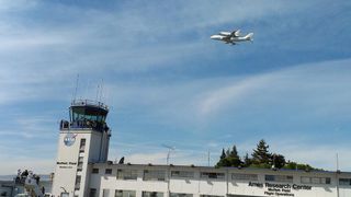 Space shuttle Endavour and its Shuttle Carrier Aircraft fly over NASA's Ames Research Center control tower at Moffett Field, Calif., during a state-wide tour on Sept. 21, 2012,