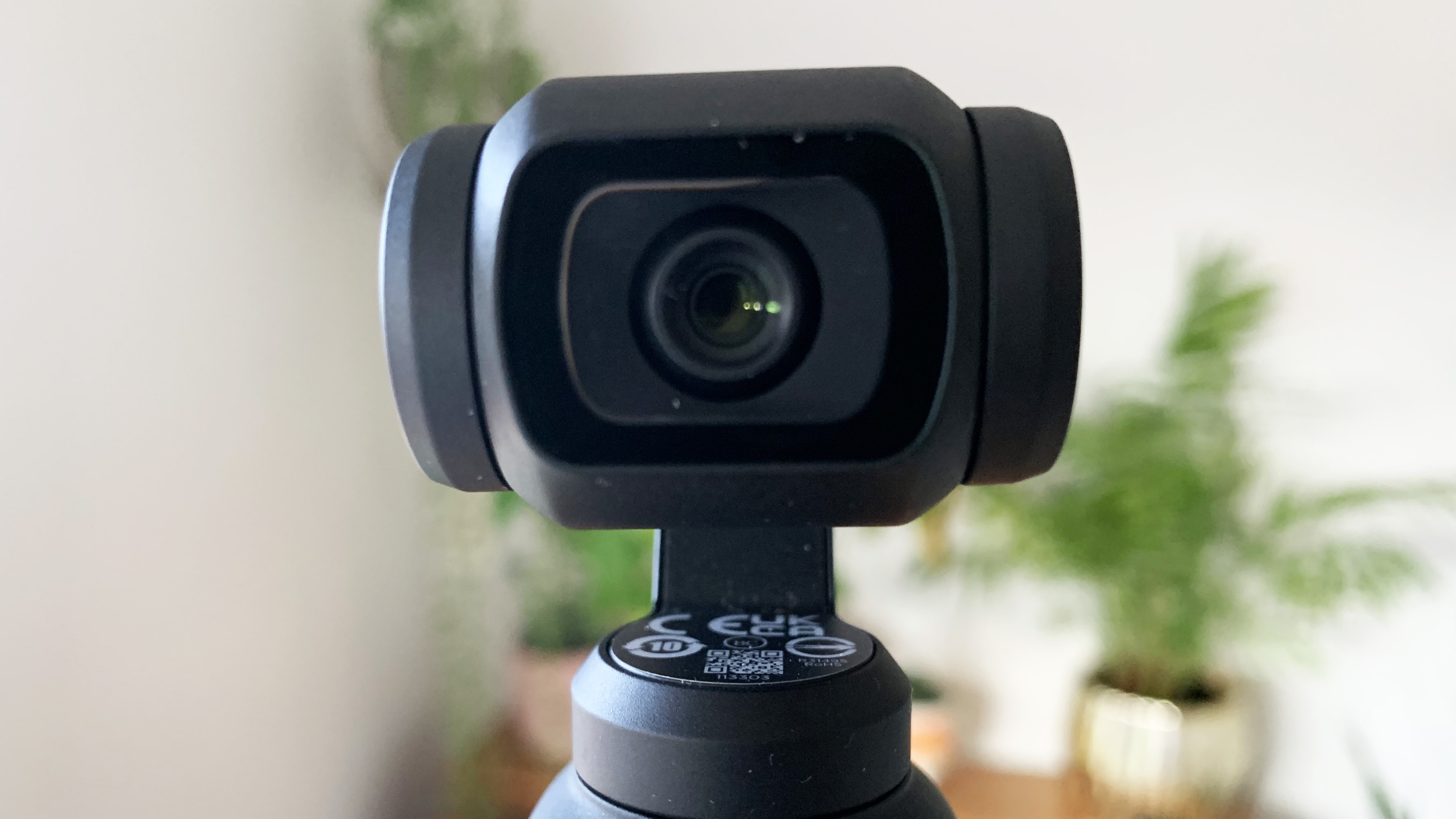 The lens of the DJI Pocket 3 camera in a living room