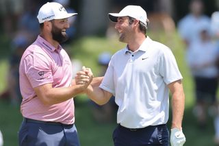 Jon Rahm of Spain reacts with Scottie Scheffler of the United States after holing out from the ninth fairway during the final round of the Memorial Tournament