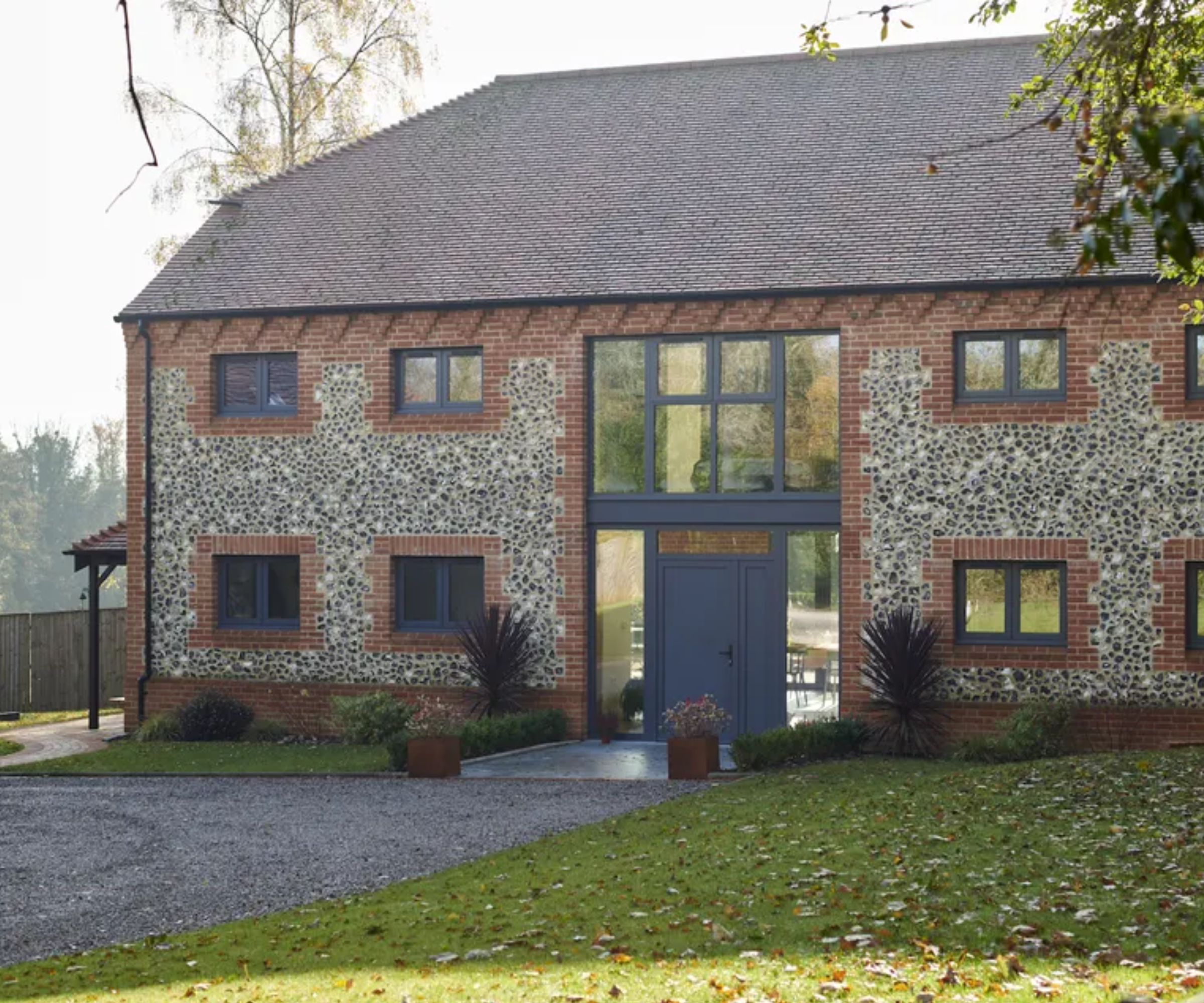 Large house with gravel and lawn in front of it