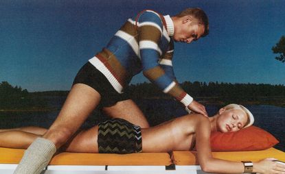 Man in striped sweater massaging a topless lady
