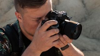 Panasonic Lumix S 100mm f2.8 Macro lens attached to a Panasonic camera held in a person's hands