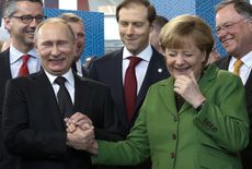 Vladimir Putin and Angela Merkel laugh.