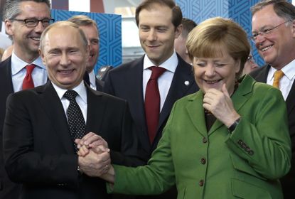 Vladimir Putin and Angela Merkel laugh.