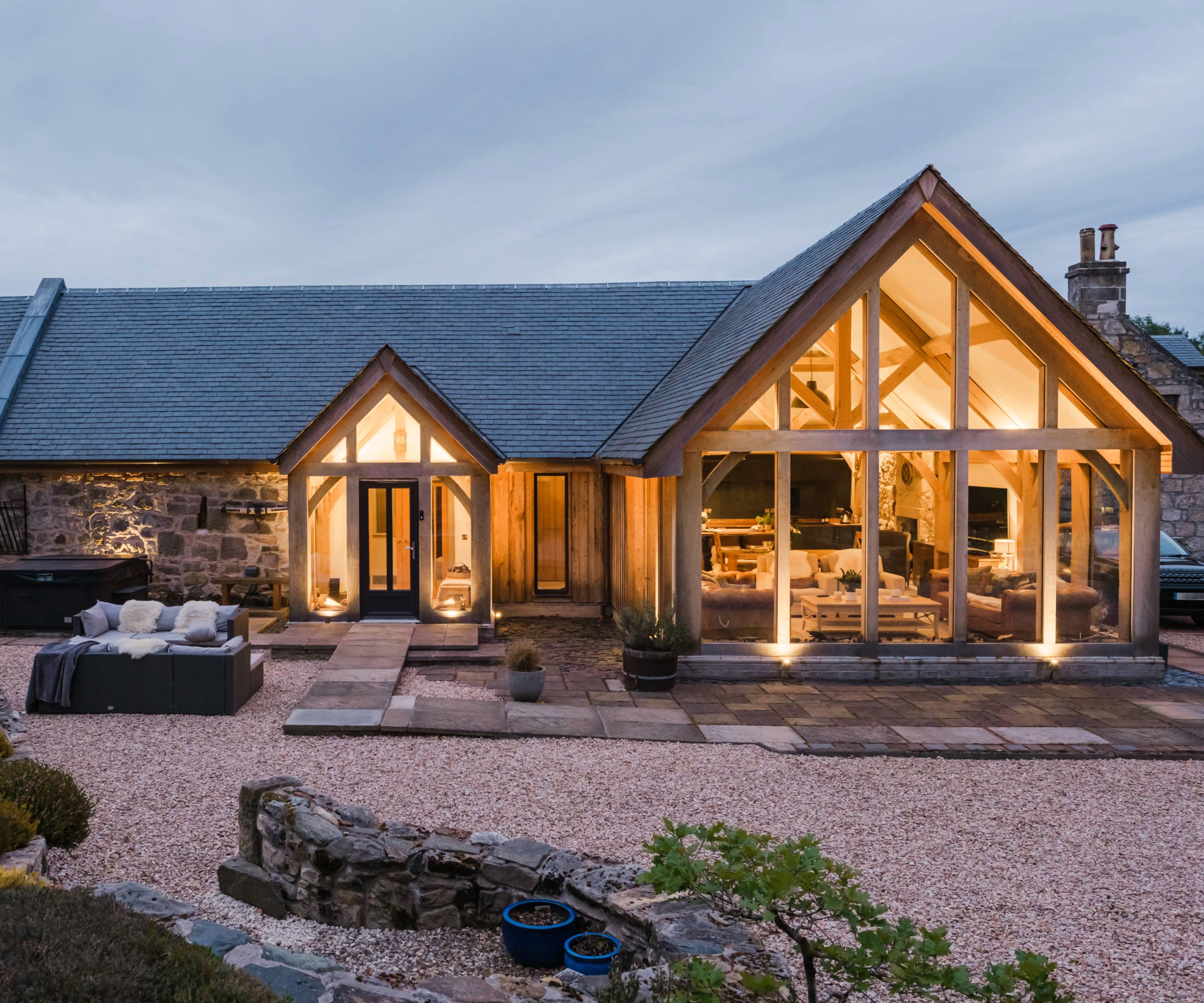 Exterior of the front of the house in the evening with the lights on inside