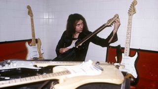 Photo of Ritchie BLACKMORE and DEEP PURPLE; Ritchie Blackmore, posed, backstage, tuning up, with collection of Fender Stratocaster guitars 