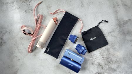 Dyson HushJet Mini Cool Fan and Shark ChillPill fans on marble-effect table with accessories