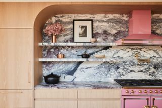 a kitchen with a bold marble backsplash