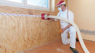cellulose insulation being blown into walls