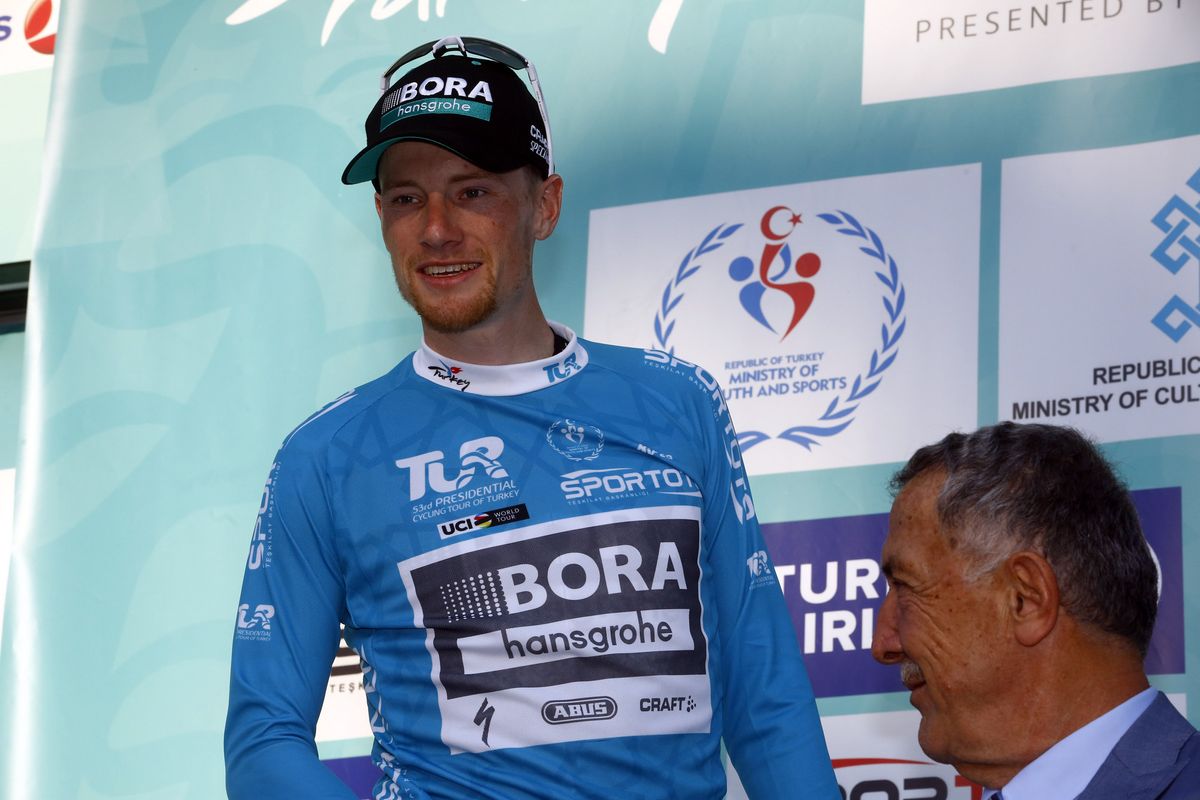 Sam Bennett pulls on the leader's jersey