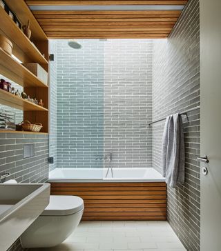 A bathroom with built-in cabinetry and tiled wall
