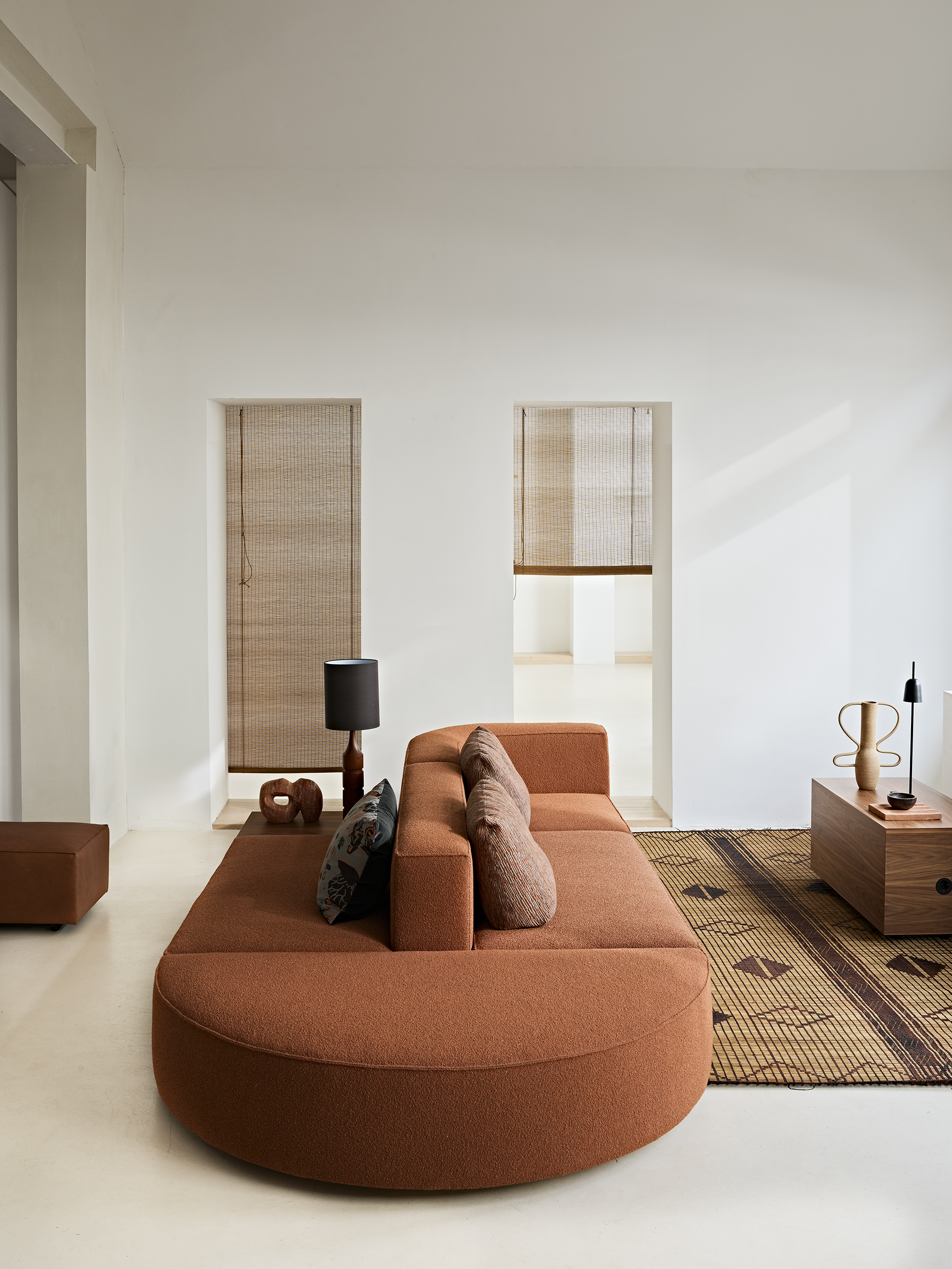 A sofa island made with modular elements upholstered in a soft, terracotta-hued fabric.