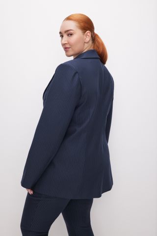 a model wears a navy blue pinstripe blazer