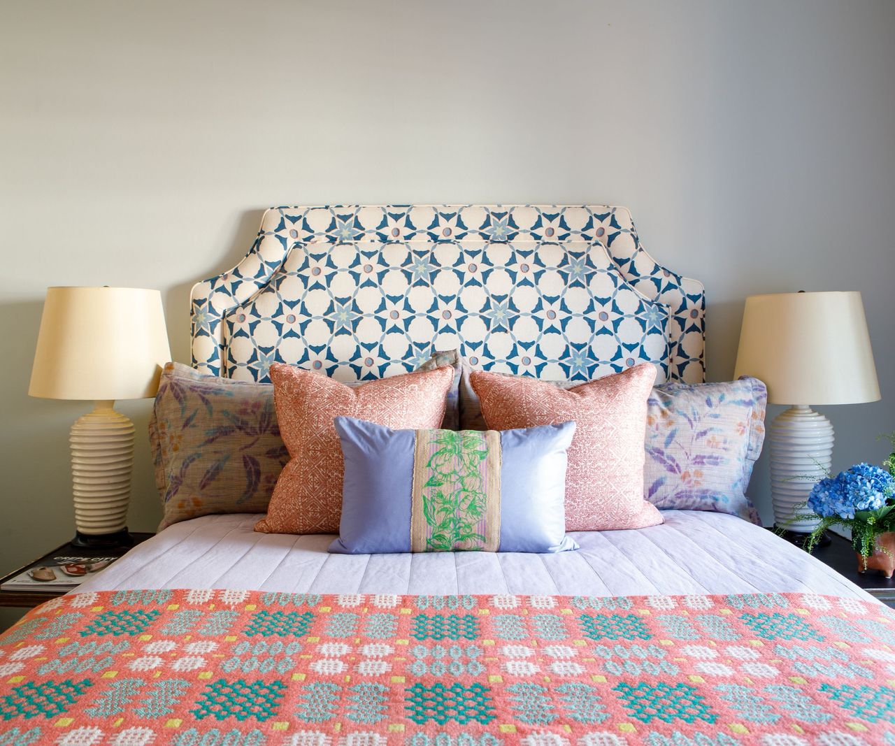 Blue and white headboard, pink and green blanket