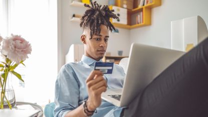 Man with credit card looking at laptop