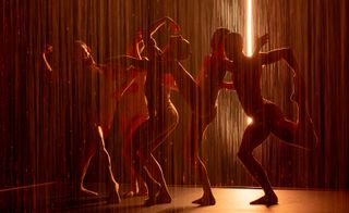 people dancing in water in red lighting