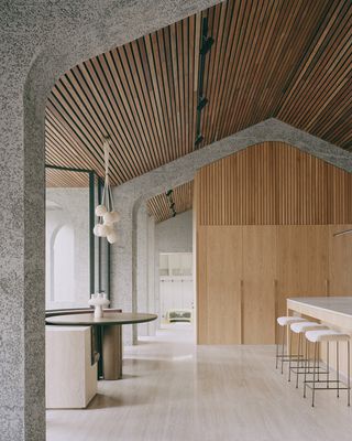 minimalist kitchen and dining area with wooden slats on the wall