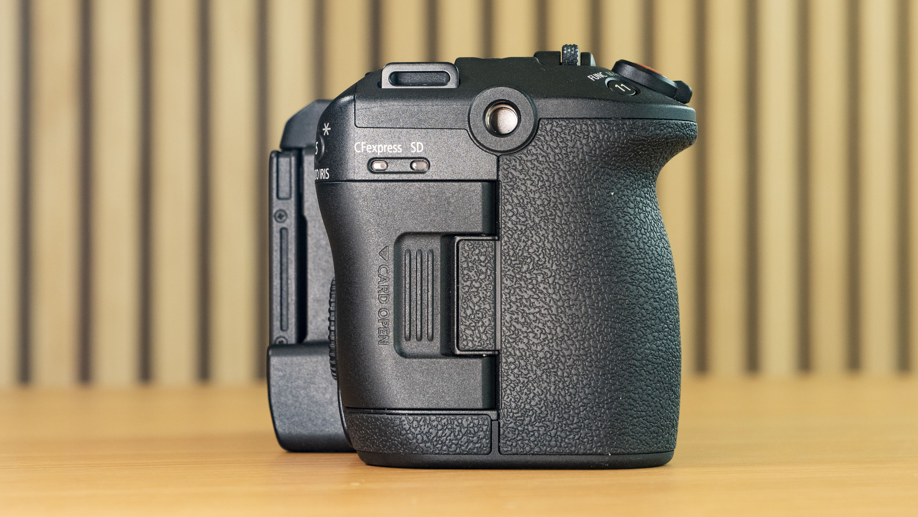Canon EOS C50 on a wooden surface, side proflie, no lens attached