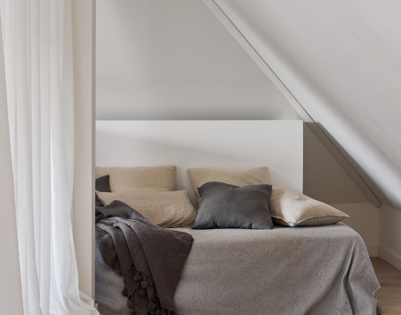 A small bedroom with a bed fit under the arched walls