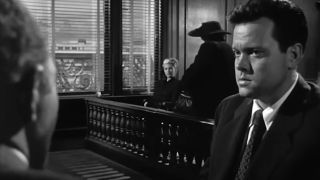 Orson Welles sits in a courtroom looking concerned in The Lady From Shanghai.