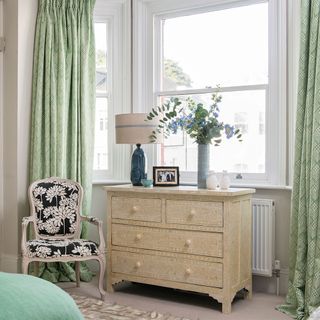 bedroom with green curtains and chest of drawers