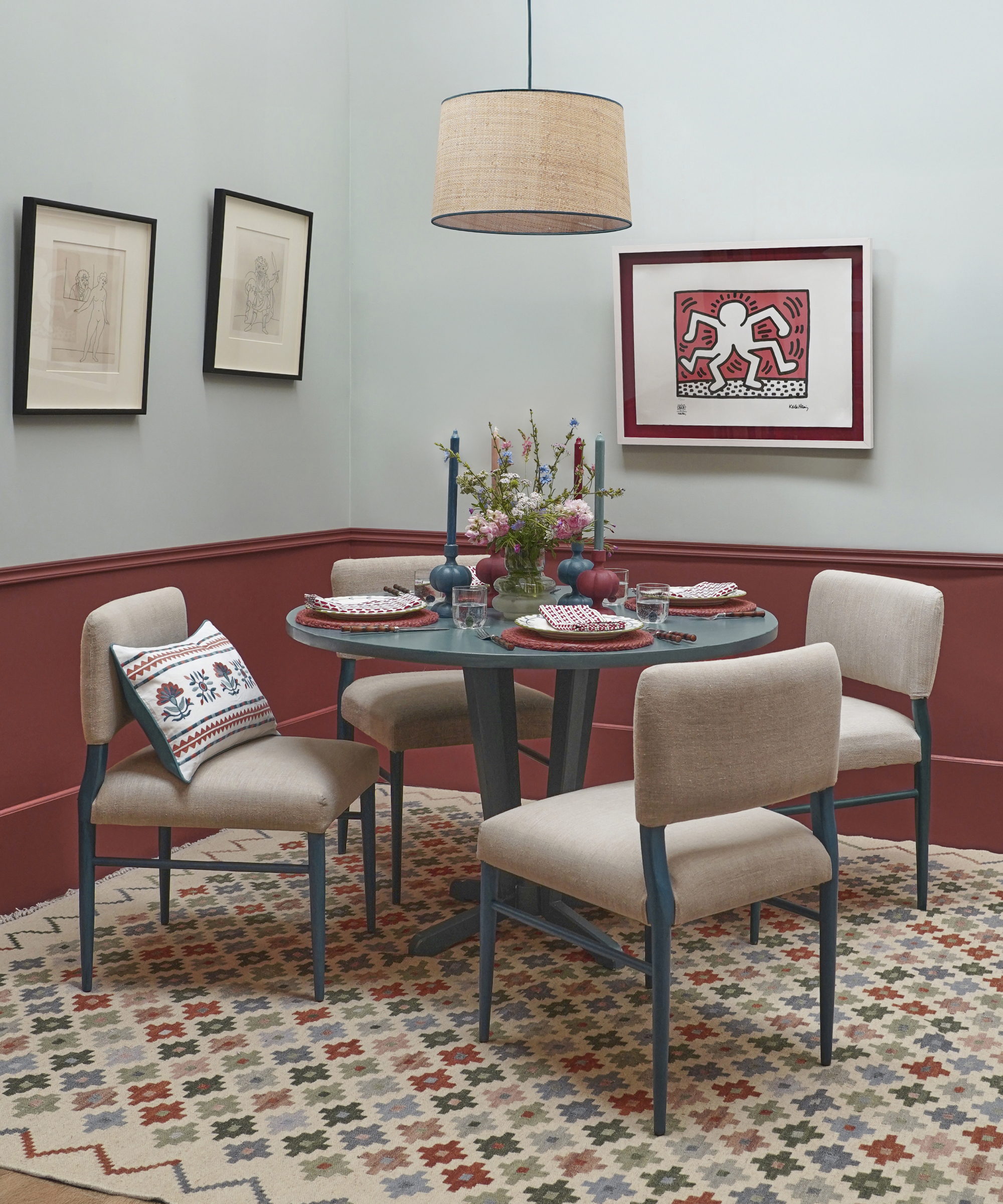 dining room with blue walls, pale burgundy wall panelling below, blue and cream chairs and a patterned rug in same shades