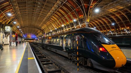 train in station at night with architecture and coloured lighting