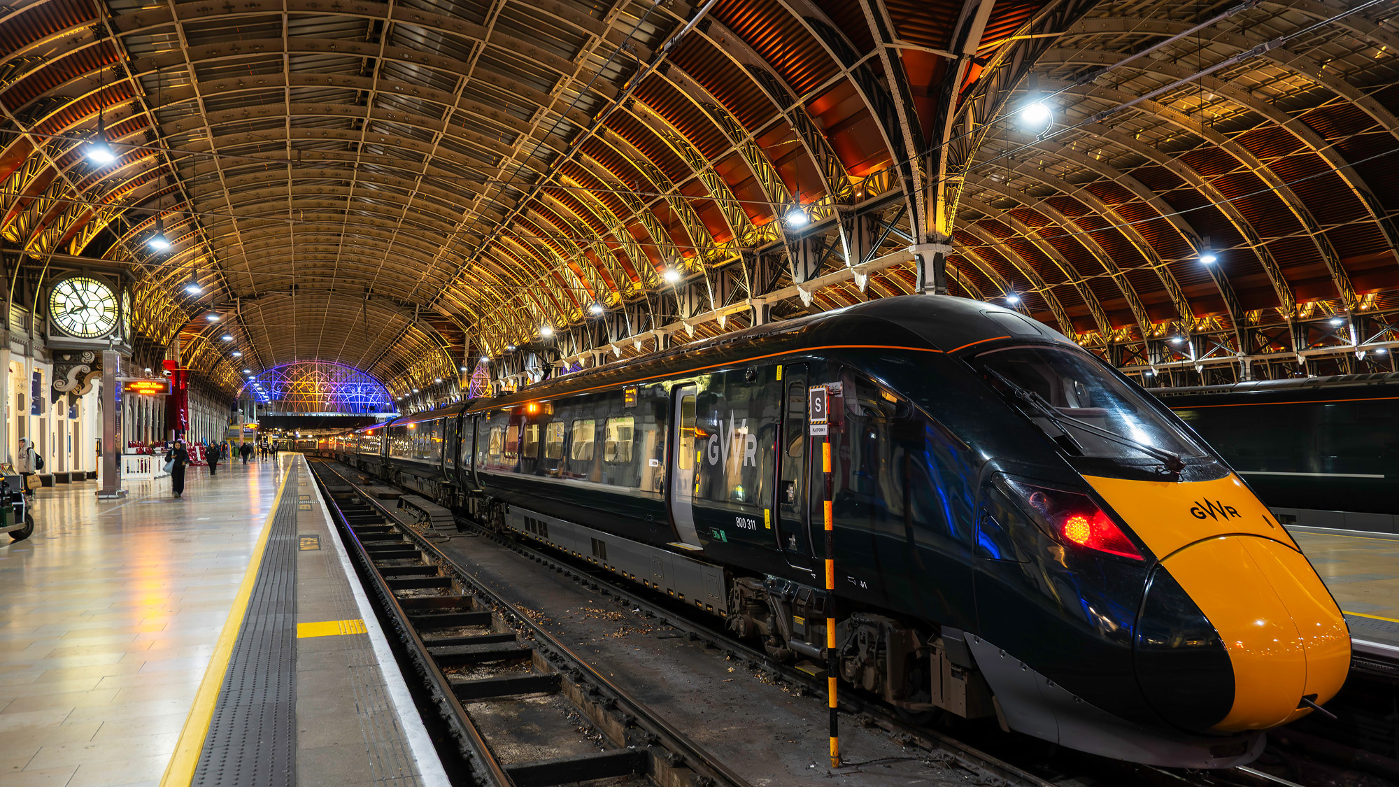 train in station at night with architecture and coloured lighting