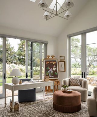 neutral home office meets art studio with a seating area with armchairs and an ottoman