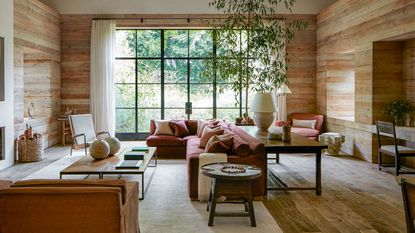 library with wooden cladding, metal framed windows and red corner sofa 