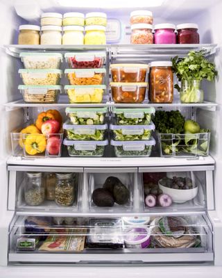 A fridge with multiple containers with prepped food in them