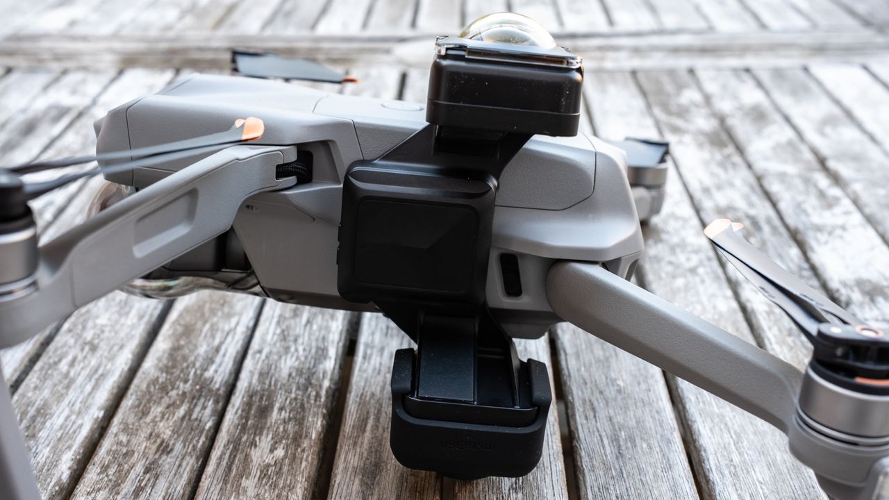 A DJI drone on a wooden table connected to the Insta360 Sphere 360 camera