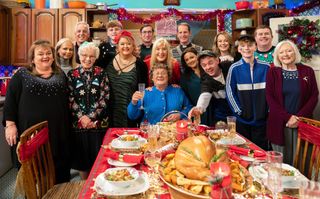 The Mrs Brown's characters cheering and laughing around a Christmas feast.