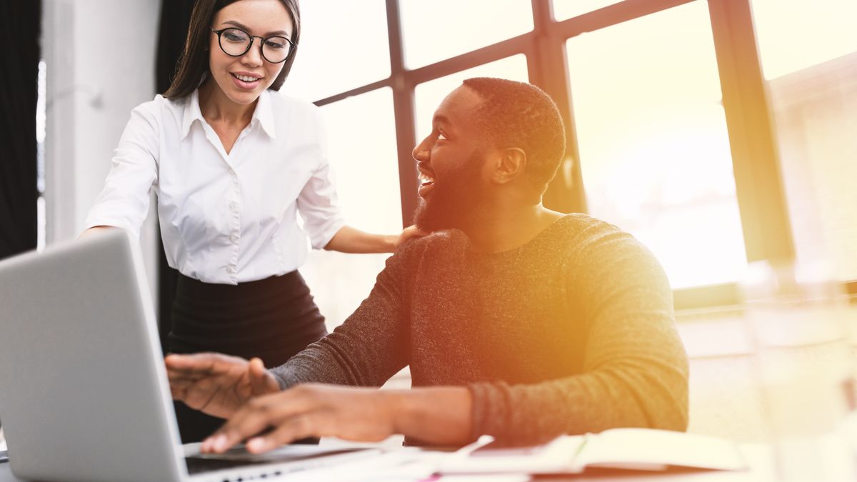 Man and woman looking at a laptop in an office