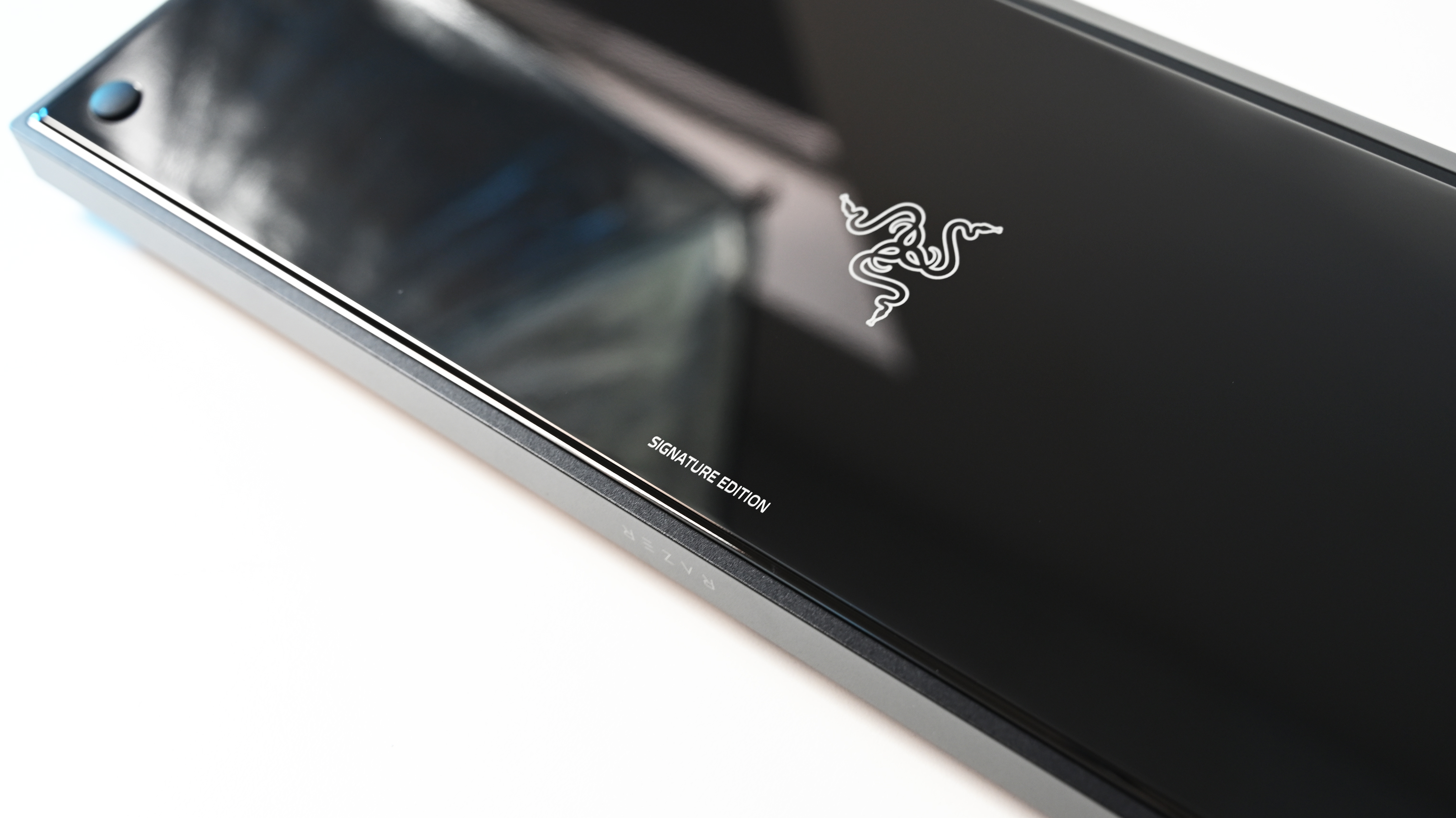 Detailed angled close-up of the keyboard&amp;rsquo;s mirror-finish underside, displaying the white Razer logo and "SIGNATURE EDITION" branding.