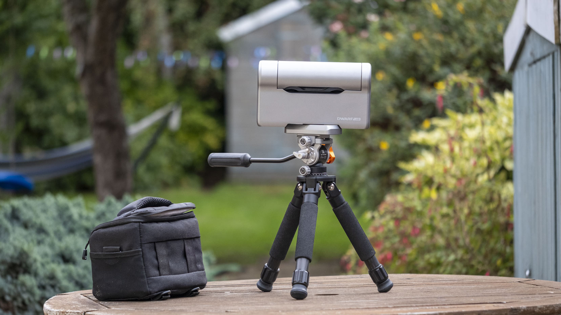 The Dwarf III smart telescope photographed in a garden, showing the rear of the device