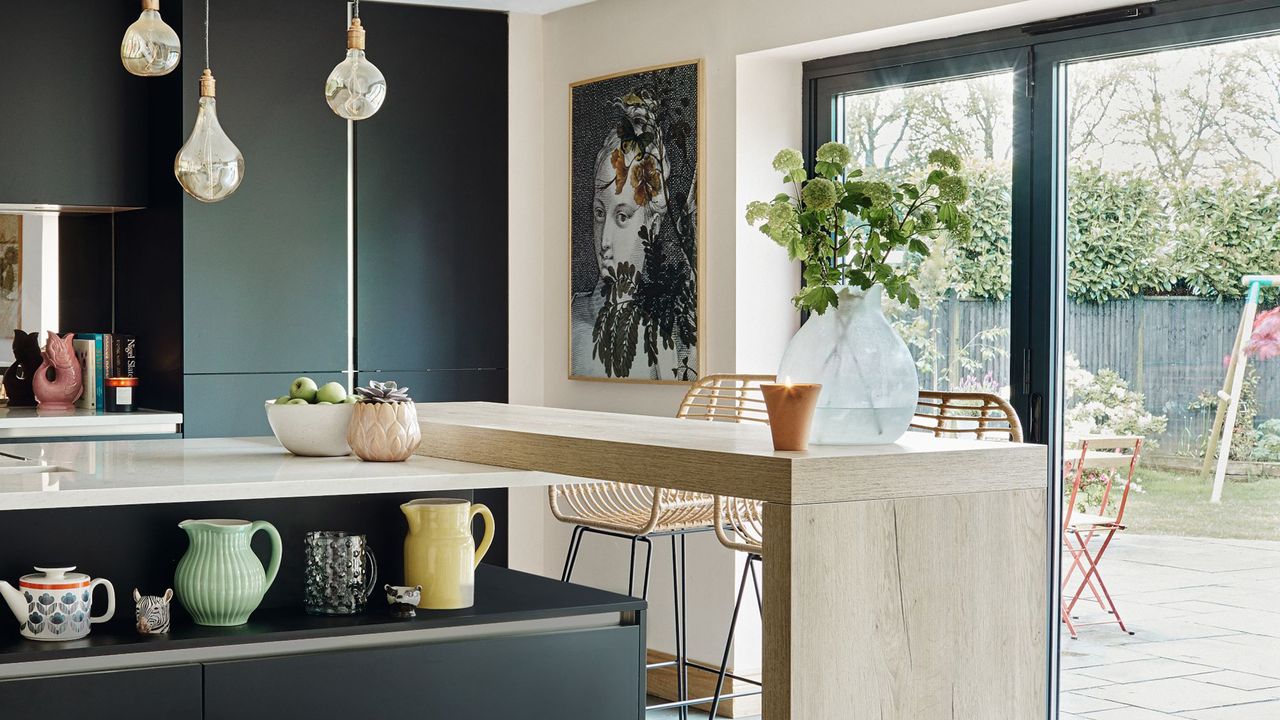 Kitchen with wooden breakfast bar and sliding doors out to garden