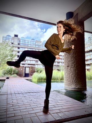 A model high kicking with her hair blowing