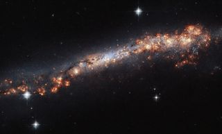 What looks like a long, narrow stretch of stars in this Hubble Space Telescope image is actually a spiral galaxy just like the Milky Way. From our position in the cosmos, we view this galaxy edge-on. Named NGC 3432, this galaxy is located about 45 million light-years from Earth in the constellation of Leo Minor.