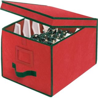 A red fabric box with a hinge lid. Inside, four white plastic dividers for wrapping tree lights around. 