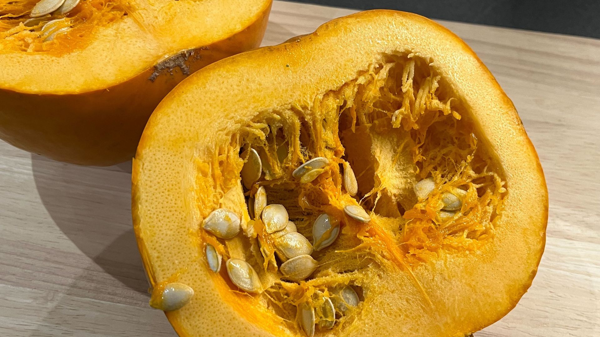 picture of cut open pumpkin with seeds and pulp inside