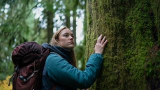 A screenshot from the movie Significant Other where a blonde woman is touching a tree with her right hand