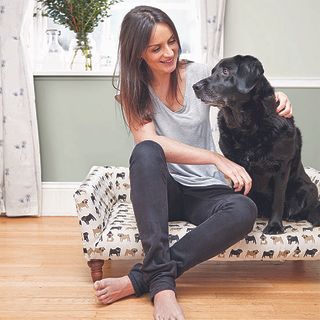 room with woman sitting with an dog